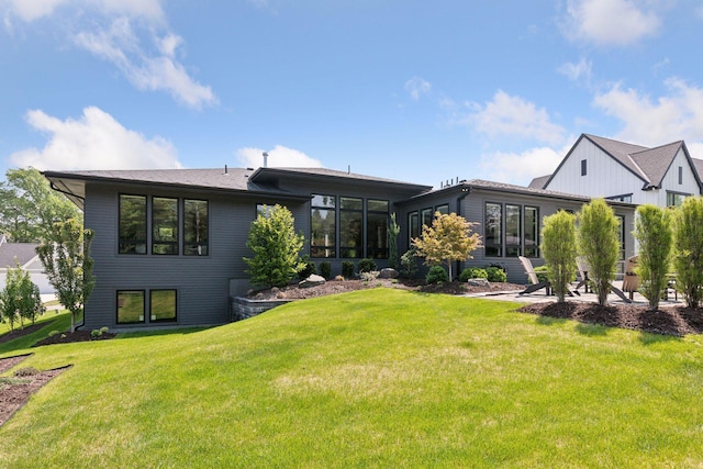 back of house featuring a lawn and a sunroom