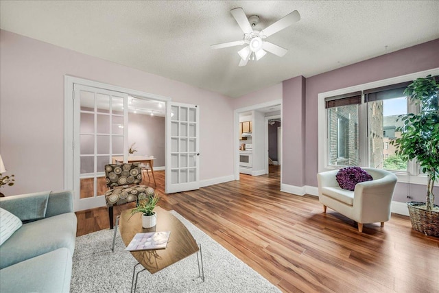 79 Western Ave N Unit 305, Saint Paul, MN 55102 - living area featuring wood finished floors, a ceiling fan, french doors, baseboards, and a textured ceiling