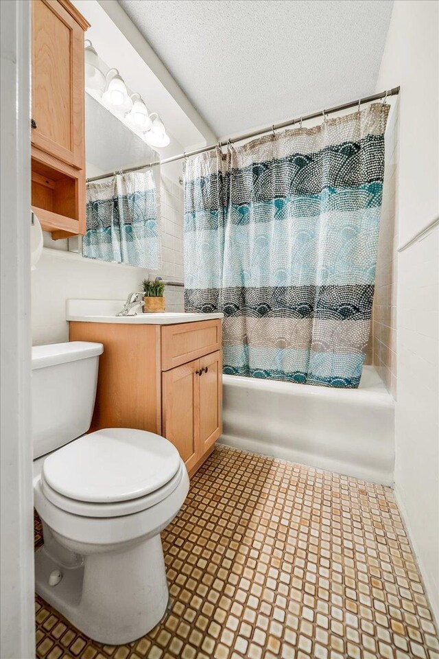 79 Western Ave N Unit 305, Saint Paul, MN 55102 - bathroom with vanity, shower / bath combo with shower curtain, toilet, a textured ceiling, and tile patterned floors