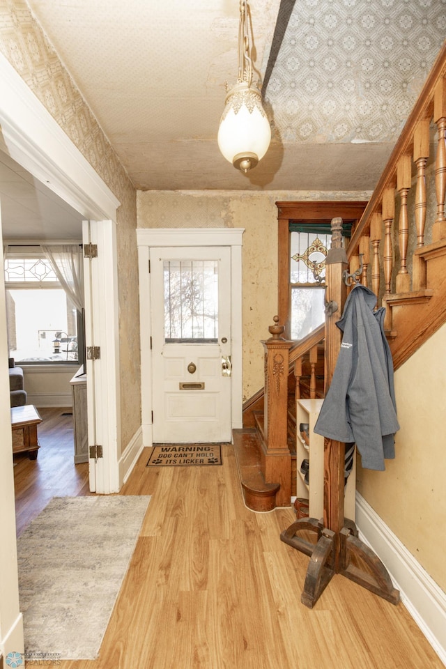 interior space with stairs, a healthy amount of sunlight, and wallpapered walls