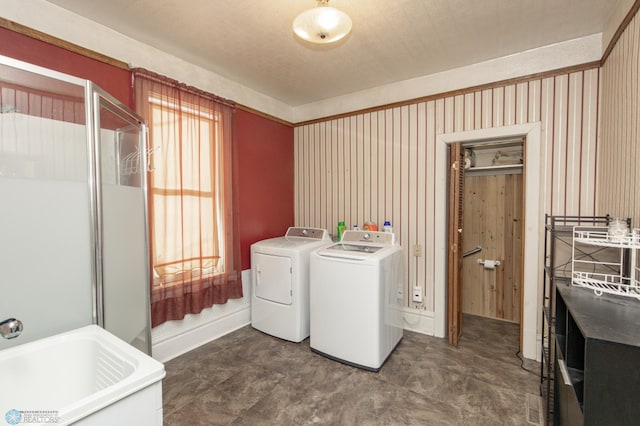 laundry room with laundry area, washer and dryer, baseboards, and a sink