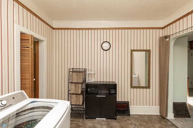 clothes washing area featuring washer / dryer, baseboards, arched walkways, and laundry area