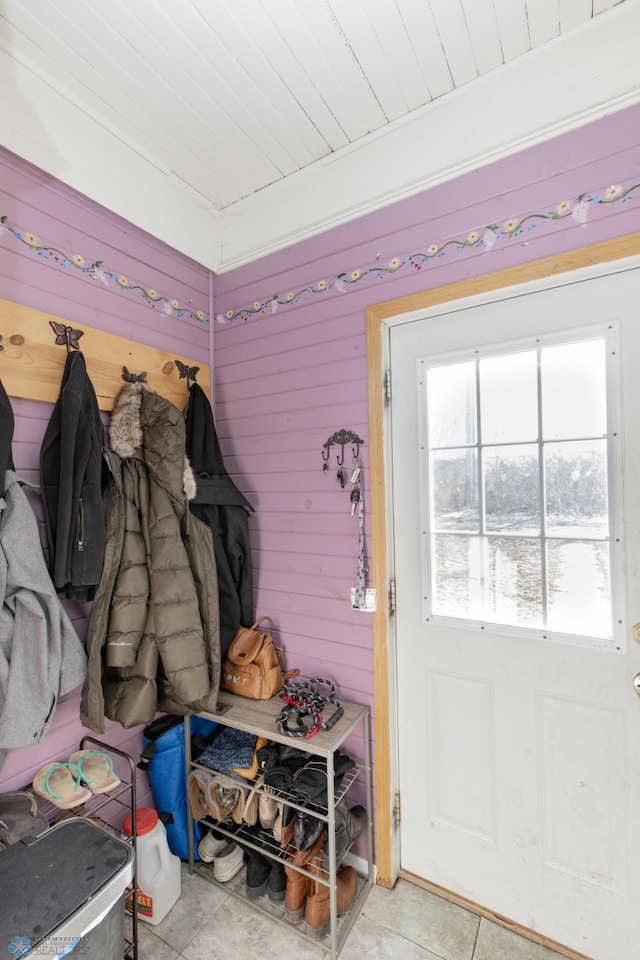 mudroom featuring light tile patterned flooring, wooden walls, and wood ceiling