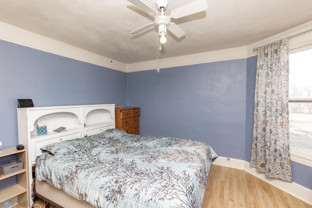 bedroom featuring a ceiling fan and wood finished floors