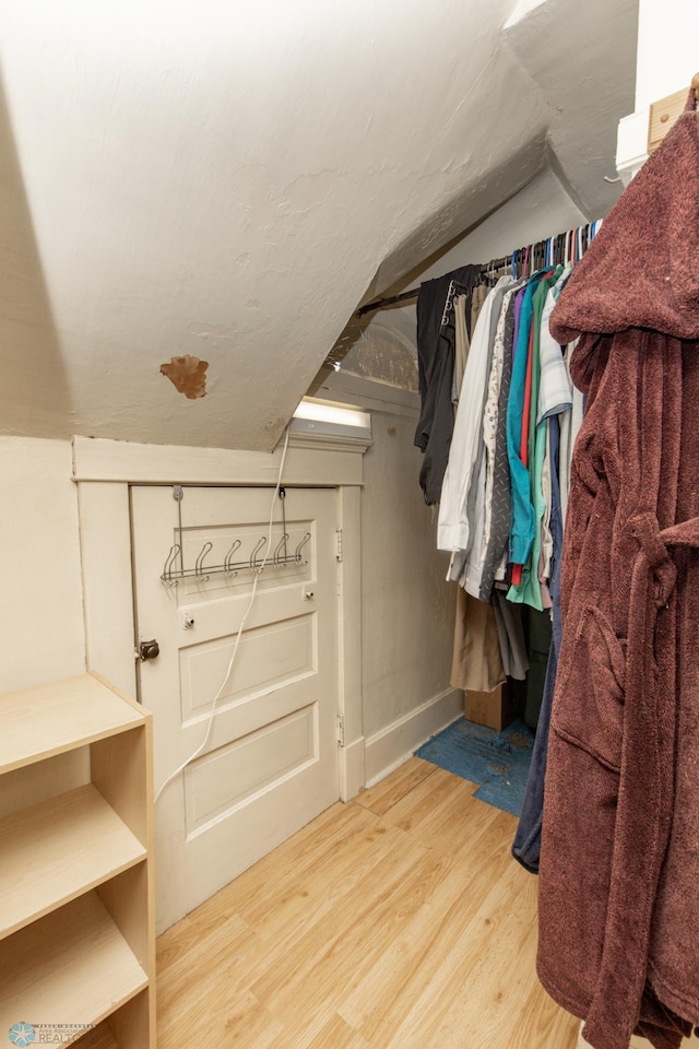 spacious closet featuring light wood-type flooring and lofted ceiling