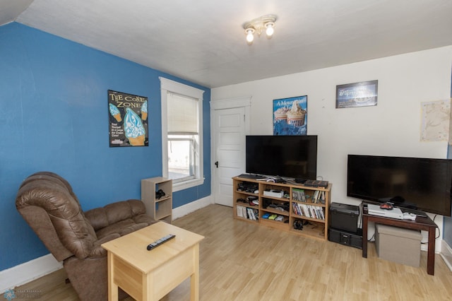 living area with baseboards and wood finished floors