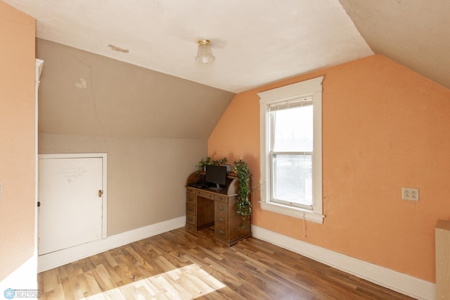 additional living space featuring vaulted ceiling, wood finished floors, and baseboards