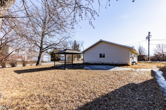 view of home's exterior with a gazebo, an outdoor structure, and a patio area