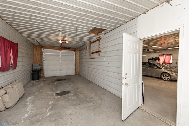 garage with a garage door opener and metal wall