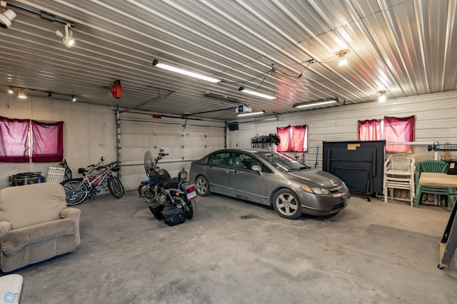 garage featuring a garage door opener and metal wall