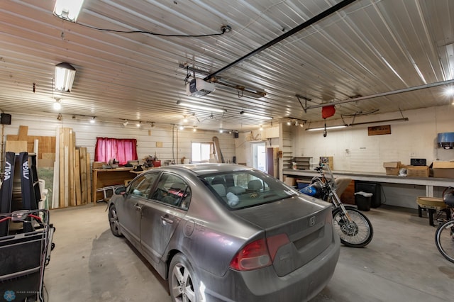 garage with a workshop area and a garage door opener