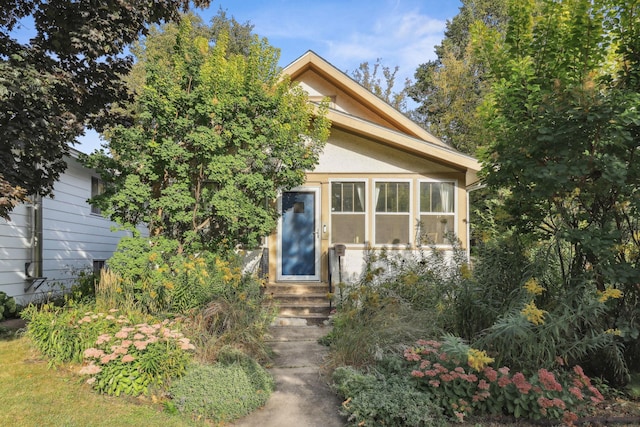 view of front facade featuring entry steps and stucco siding