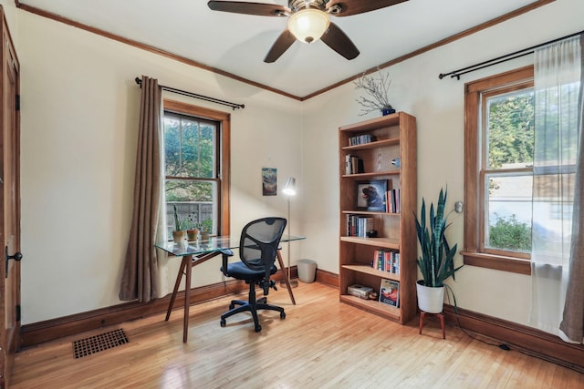 office area featuring ornamental molding, a wealth of natural light, wood-type flooring, and visible vents