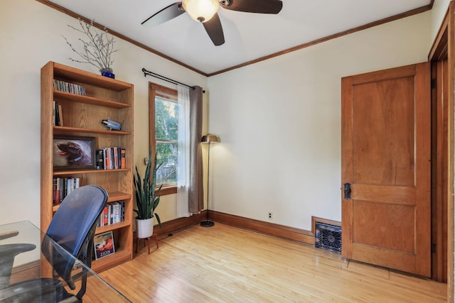 home office with crown molding, visible vents, a ceiling fan, light wood-type flooring, and baseboards