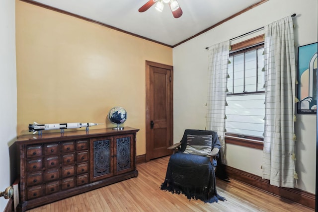 sitting room with ceiling fan, crown molding, baseboards, and wood finished floors