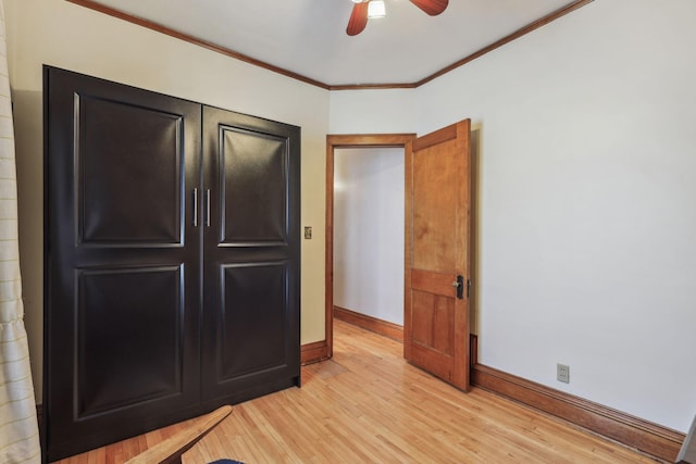 unfurnished bedroom with a ceiling fan, baseboards, crown molding, and light wood finished floors