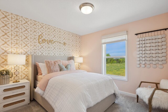 carpeted bedroom featuring wallpapered walls, an accent wall, and baseboards