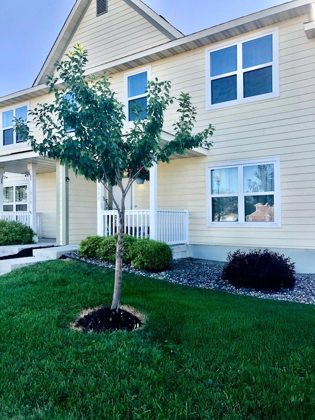 view of front of home with a porch and a front lawn