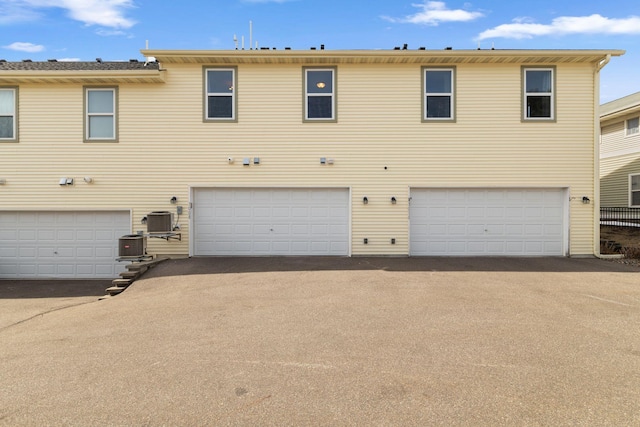 multi unit property featuring central air condition unit and a garage