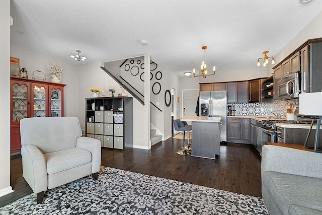 living area with dark wood-style floors, baseboards, stairs, a textured ceiling, and a chandelier