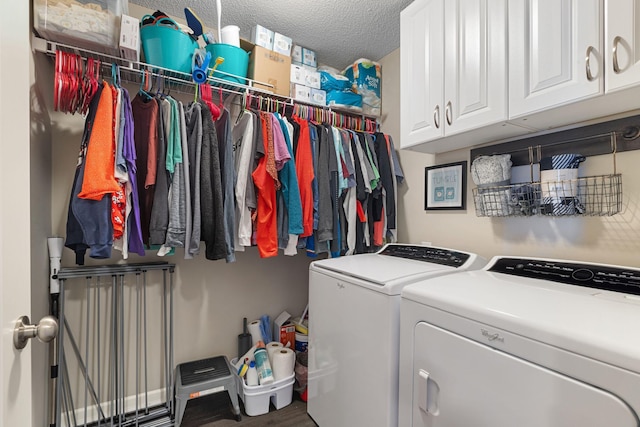 washroom with cabinet space, washing machine and dryer, and a textured ceiling