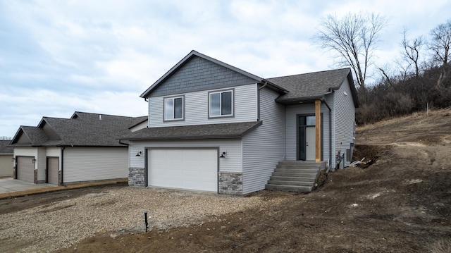 view of front of home featuring a garage, stone siding, roof with shingles, and driveway