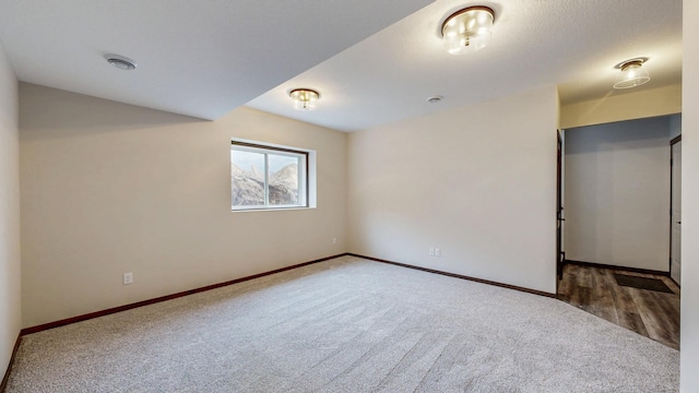 carpeted spare room featuring baseboards