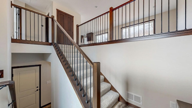 stairway featuring visible vents and baseboards