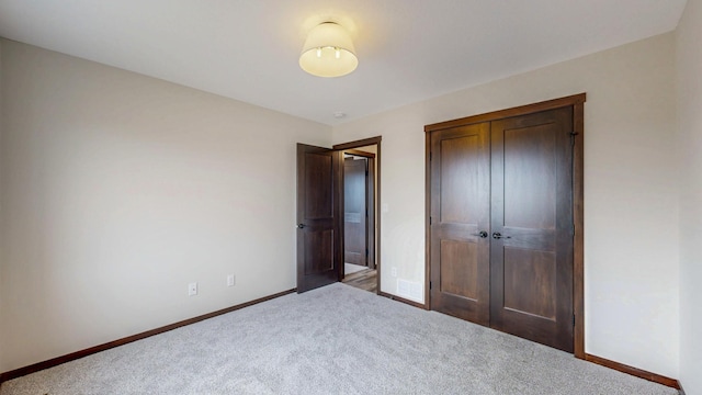 unfurnished bedroom with carpet floors, baseboards, and a closet