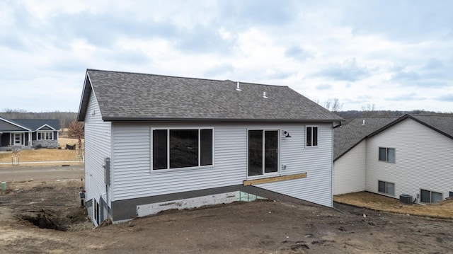 back of property featuring central air condition unit and a shingled roof