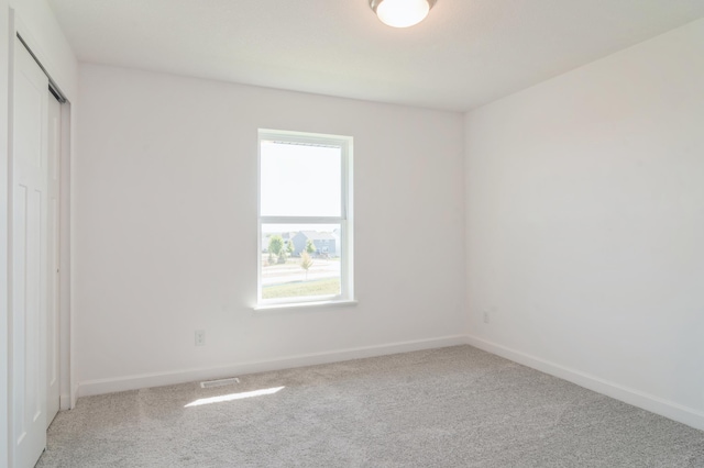 unfurnished room with carpet floors and baseboards