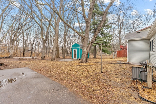 view of yard with central AC unit, an outdoor structure, and fence