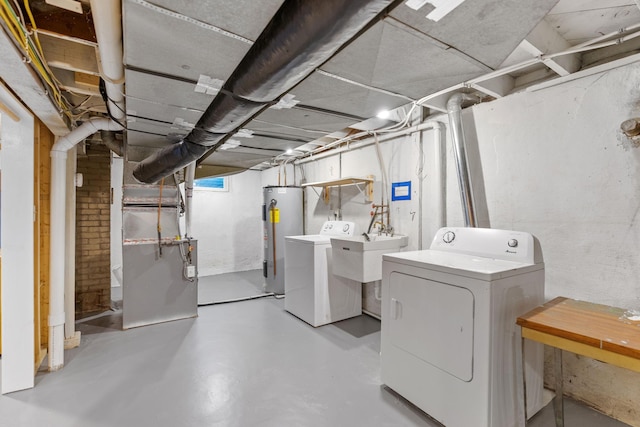 basement featuring heating unit, independent washer and dryer, and water heater