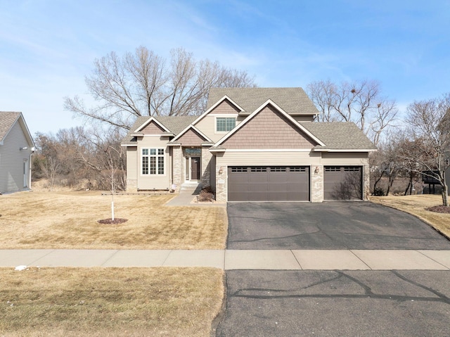 craftsman-style house with stone siding, driveway, an attached garage, and a front yard