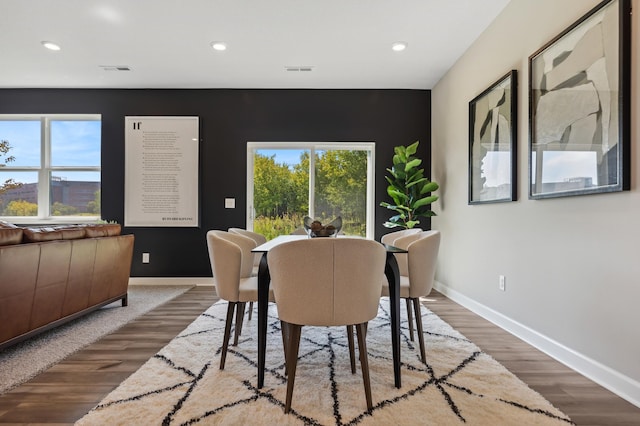 dining space featuring wood finished floors, visible vents, and baseboards