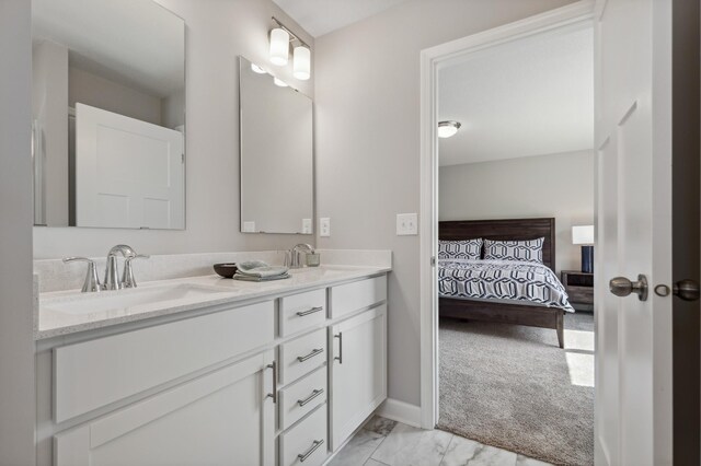 ensuite bathroom with double vanity, baseboards, ensuite bath, marble finish floor, and a sink