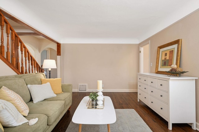 living room with baseboards, visible vents, arched walkways, dark wood-type flooring, and stairs