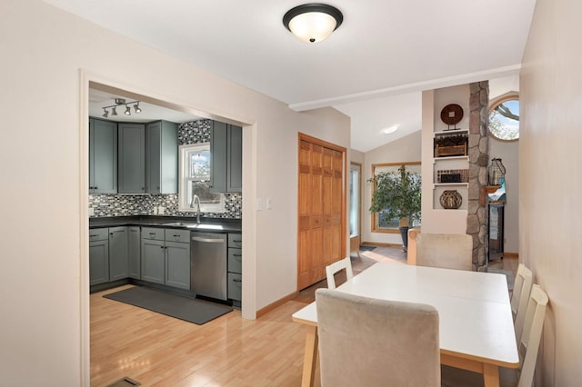 dining space featuring light wood-type flooring, baseboards, and lofted ceiling