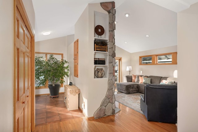 hallway featuring lofted ceiling, recessed lighting, and wood finished floors