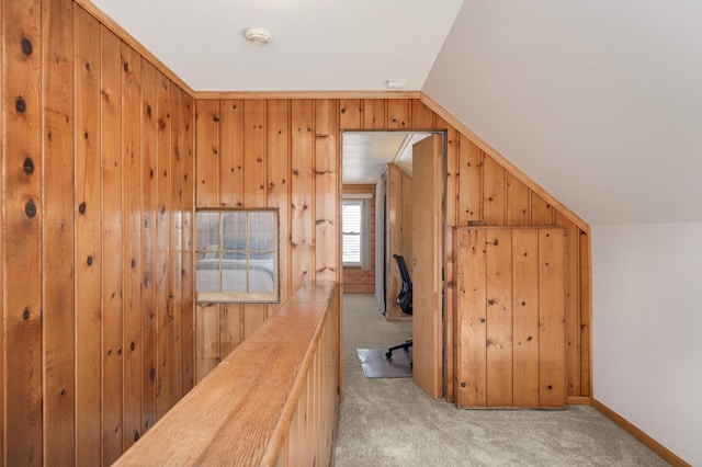 additional living space with carpet flooring, vaulted ceiling, wood walls, and baseboards