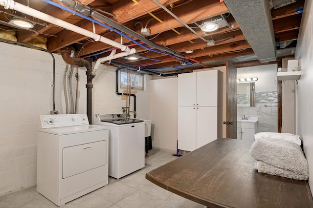 laundry area featuring a sink, washing machine and clothes dryer, and cabinet space