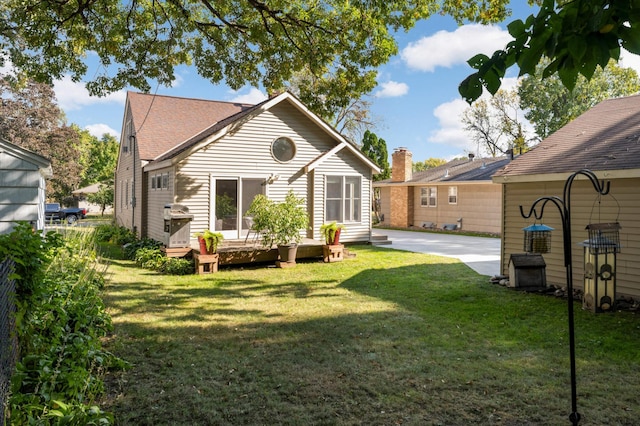 back of house featuring a deck and a yard