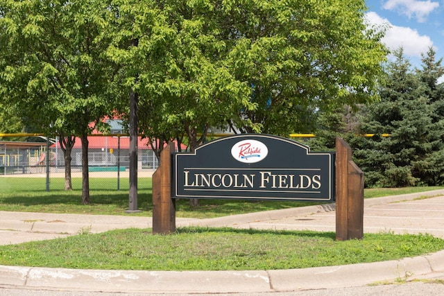 community / neighborhood sign featuring fence