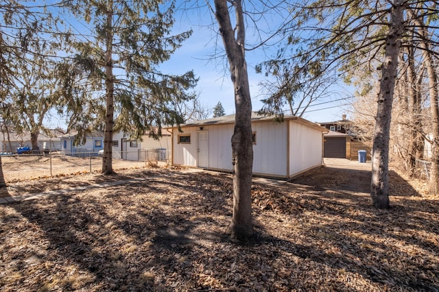 rear view of property with fence and an outdoor structure