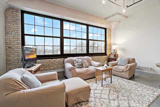 living area with brick wall and finished concrete floors