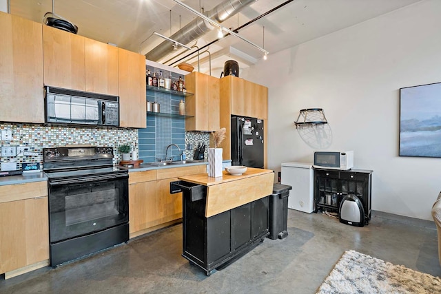 kitchen with light brown cabinetry, backsplash, black appliances, and a sink