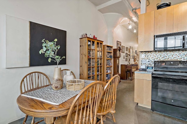 dining room with track lighting and finished concrete flooring