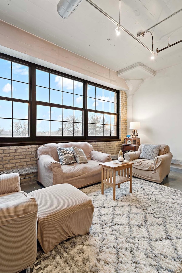 living area featuring brick wall