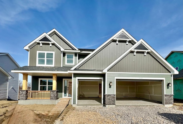 craftsman house with a garage, stone siding, and covered porch