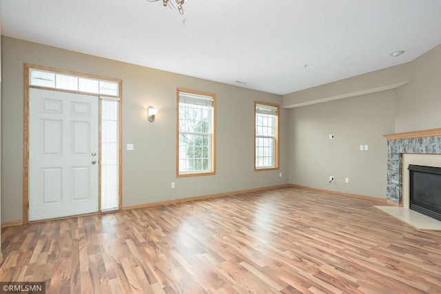 entryway featuring light wood-style floors, a fireplace, and baseboards